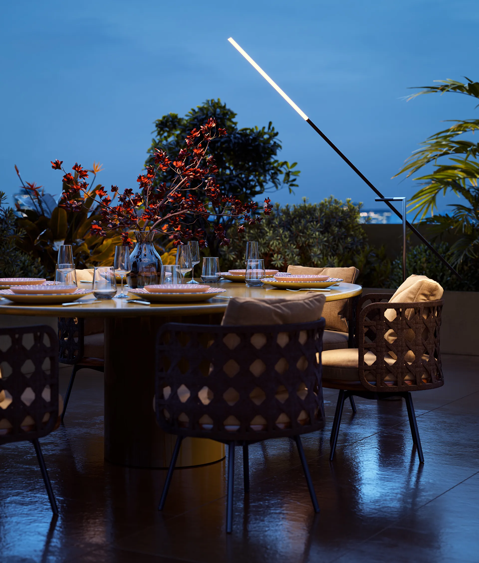 Zona pranzo all'aperto sulla terrazza di DONO Sky Collection, con tavolo elegante, sedute di design e panorama serale.