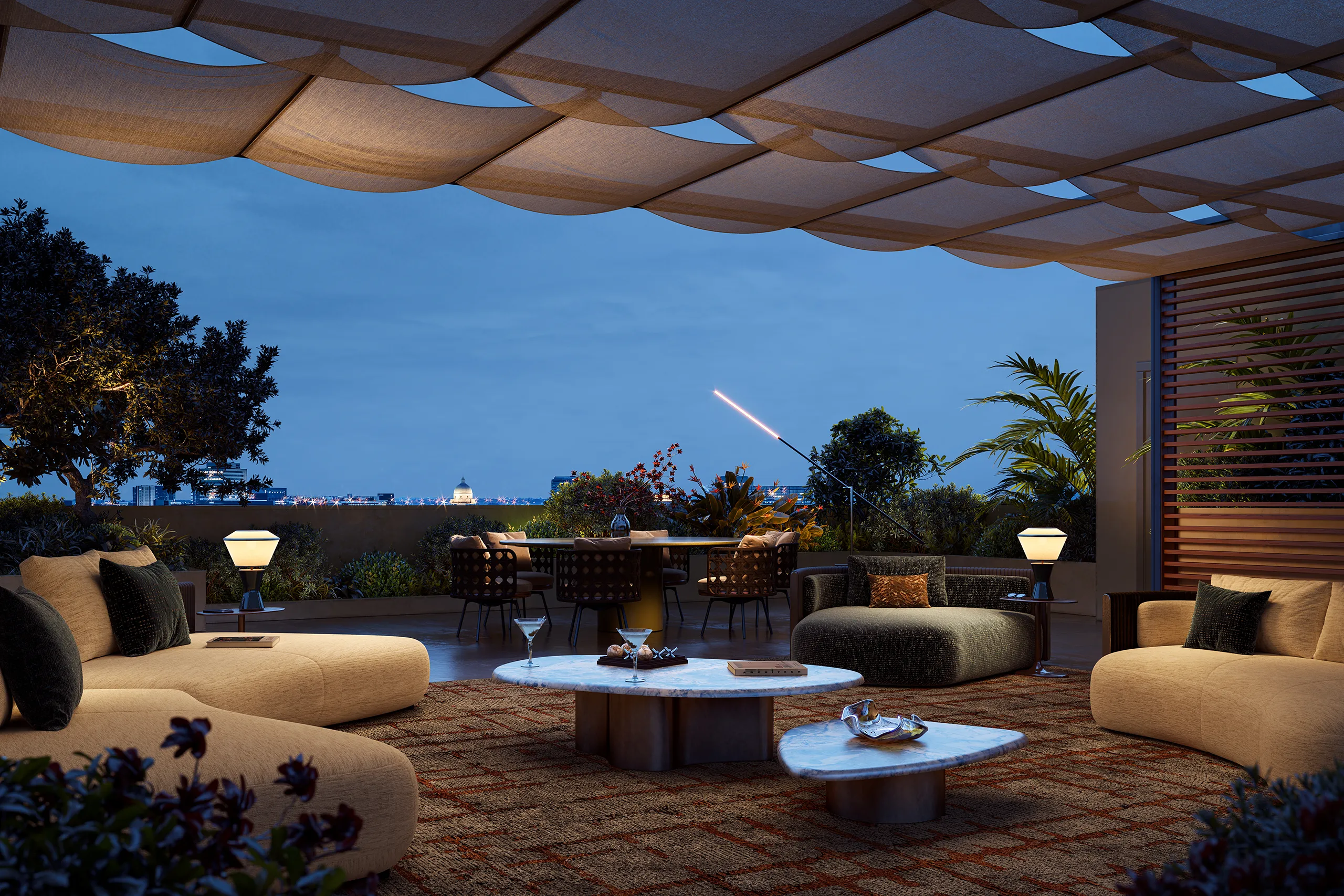 Terrazza panoramica di un attico in vendita a Roma EUR, con salotto esterno, zona pranzo e vista sulla città al crepuscolo.